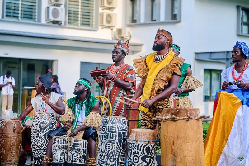 Traditional drummers in beaded regalia welcome guests outside the venue