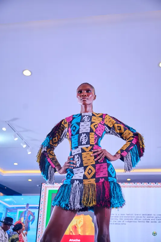 A model poses in a fringed, multicoloured patchwork dress