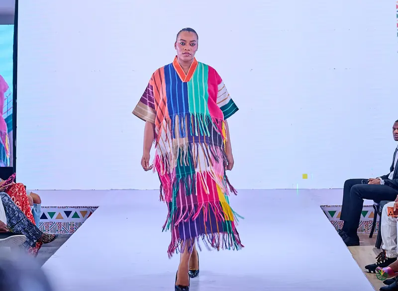 A model walks the runway in a striped fringe kaftan