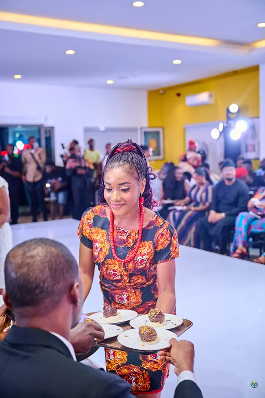 A host serves plated desserts to guests along the runway