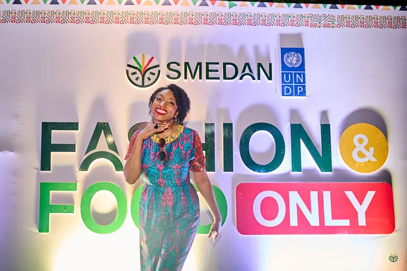 The host speaks in front of the Fashion & Food Only backdrop