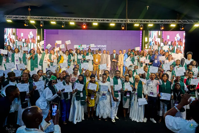 Hundreds of ICSS graduates hold up their certificates on stage