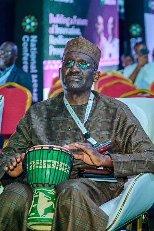A delegate smiles over a djembe during the drum session