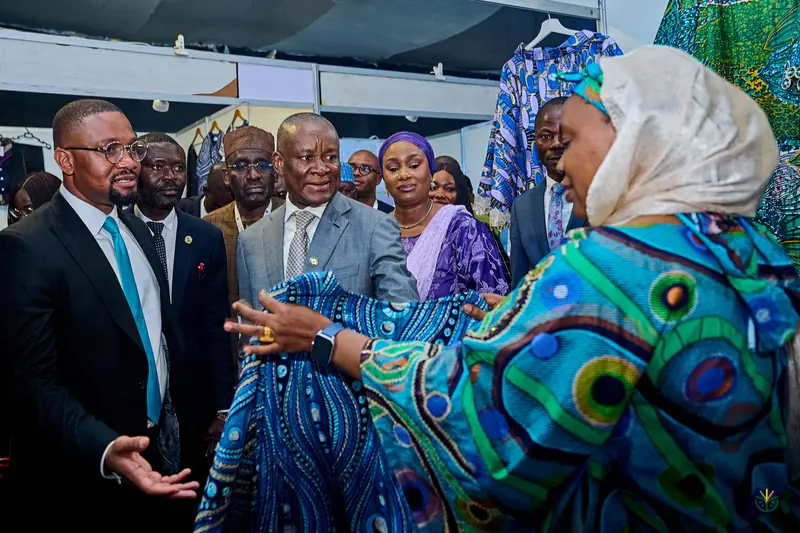 An exhibitor shows her fabrics to visitors