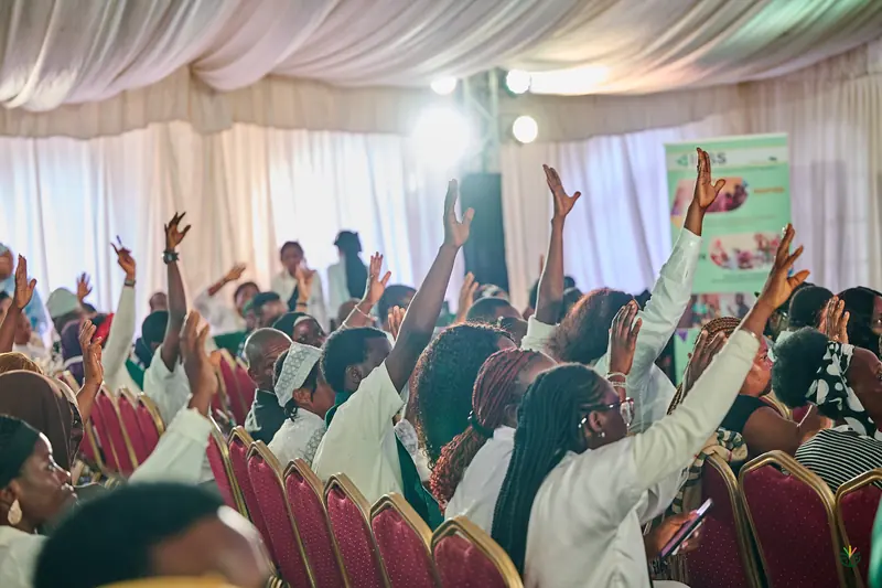 Hands up across a packed breakout session