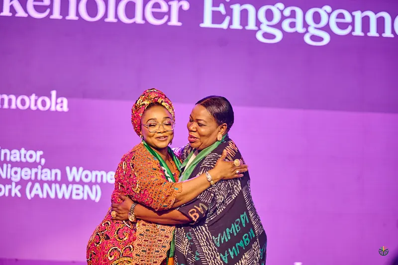 An embrace on stage during the stakeholder engagement