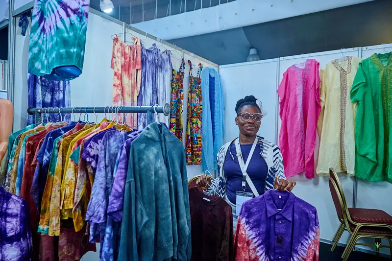 An exhibitor with her rack of hand-dyed clothing