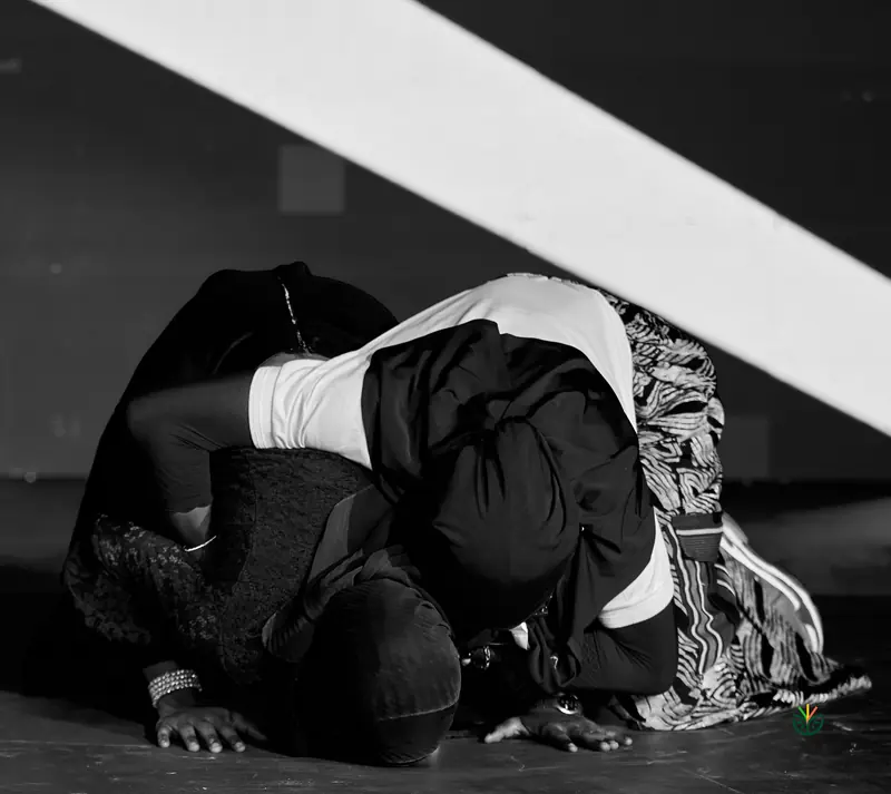 A winner kneels on the stage in gratitude