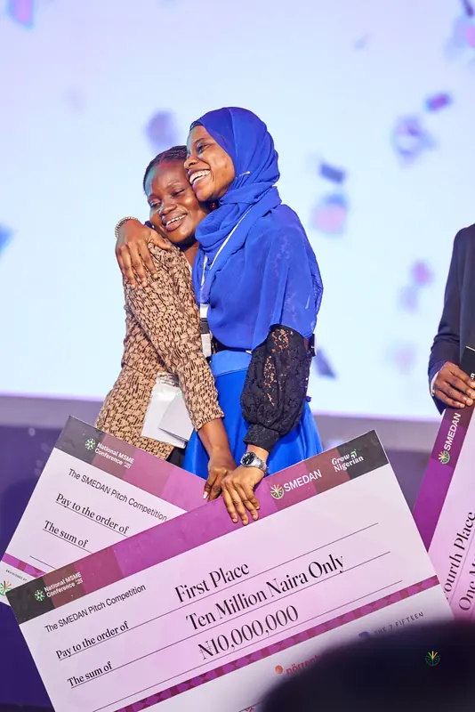 The winner embraces a supporter, cheque in hand